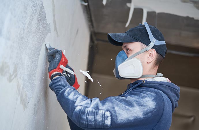 Professional worker restoring smoke damaged drywall