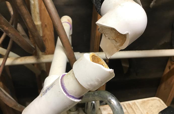 broken water pipe with ice frozen and water dripping pipe repair
