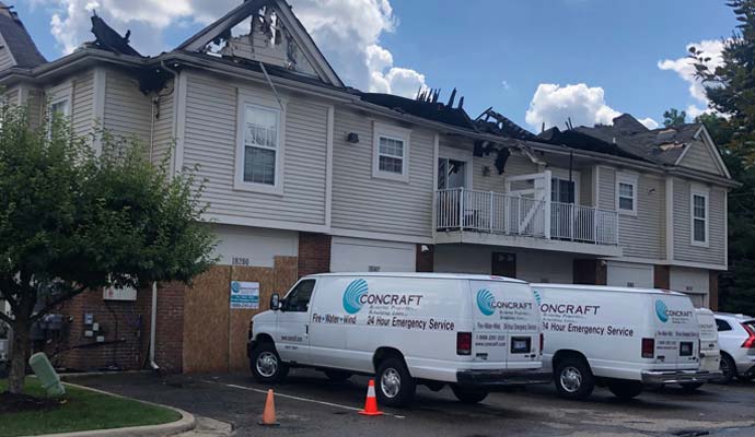 Concraft emergency restoration vans parked outside a residential building