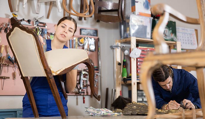 Professional experts restoring old furniture to its original condition using specialized tools