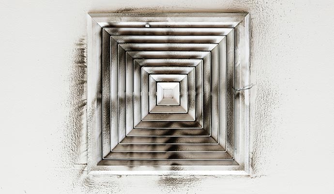 Air duct showing visible layers of dust buildup inside, indicating need for cleaning