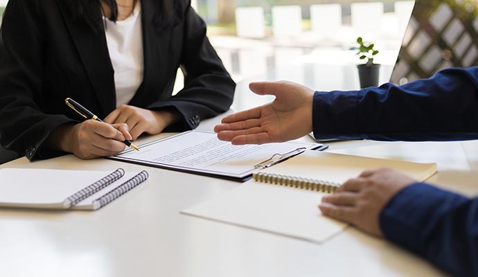 Insurance document review session between assistant and client Professional meeting between assistant and client over insurance paperwork