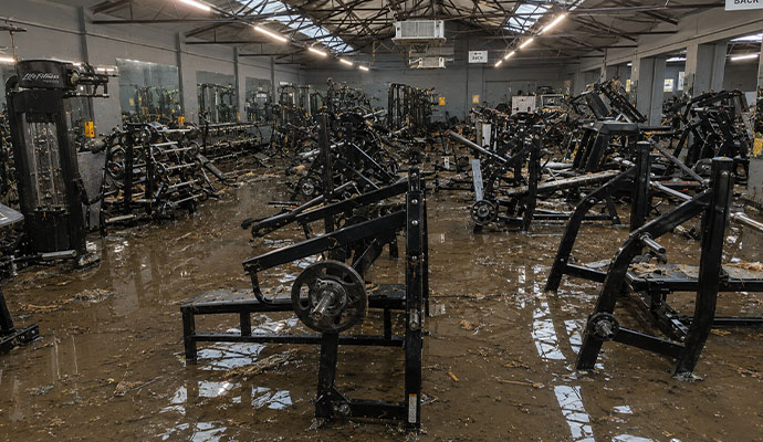 Flood-damaged gym interior with standing water