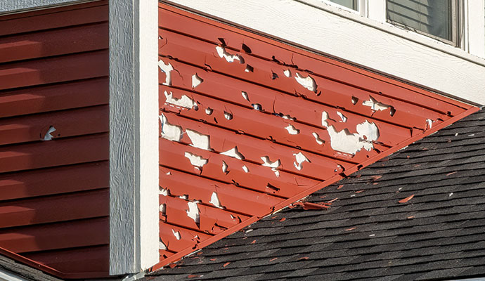 Hail damaged red vinyl siding