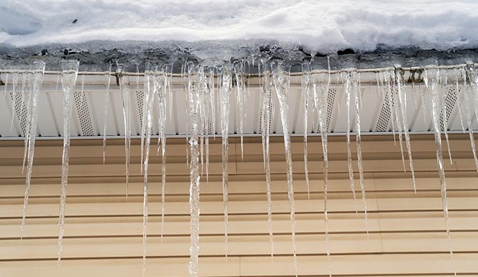 Icicles hanging from a snow-covered roof and gutter
