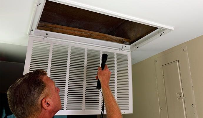 Professional worker inspecting fire damaged duct