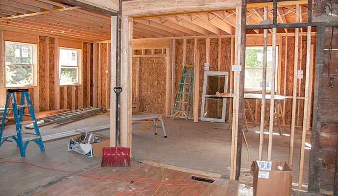 Interior of house under reconstruction with exposed wooden framing Interior view of a house under reconstruction with exposed wooden framing and construction materials