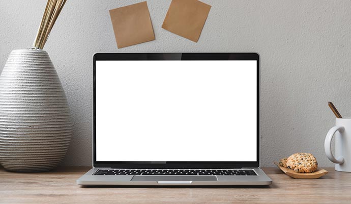 Laptop with a blank white screen on a desk