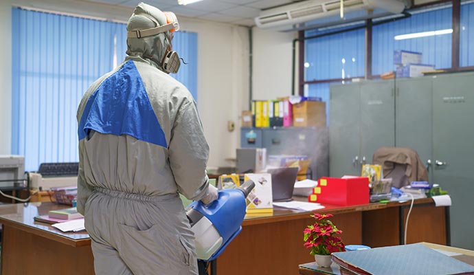 Restoration professional removing smoke odor from a government office using fogging machine