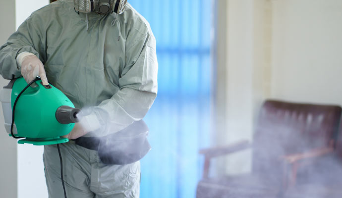 Person sanitizing in a room with equipment