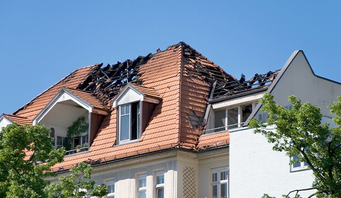 Fire damaged residential roof with charred rafters