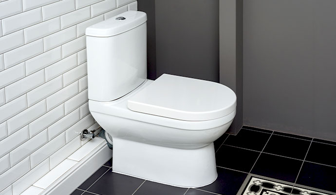 White porcelain toilet in tiled bathroom