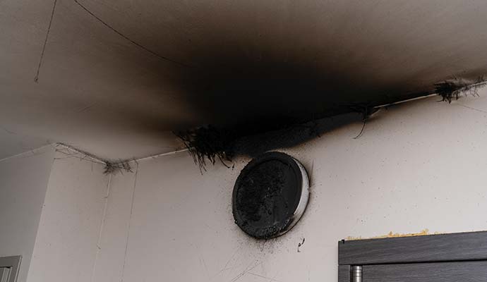 Smoke and soot damage on ceiling and wall after a fire Smoke and soot damage on ceiling and wall after a fire