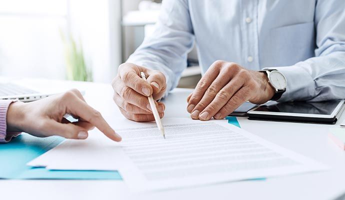 Professional meeting between assistant and client over insurance paperwork