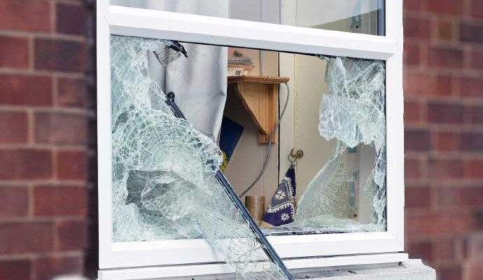 Broken and shattered window glass on home property