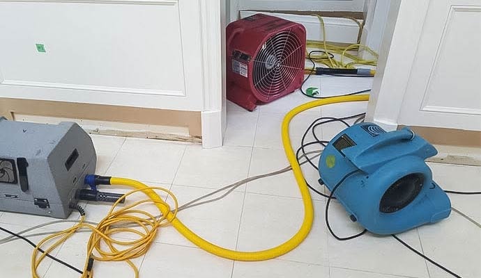 Water damage drying equipment and air mover in a room